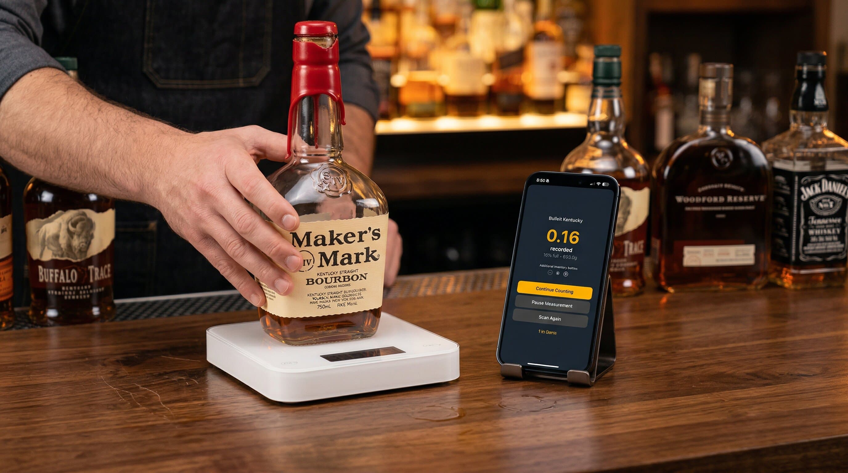 Bartender placing a bottle of Maker's Mark on a Bluetooth scale with the Lixor app showing the weight reading